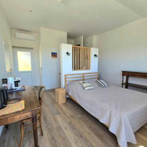 a bedroom with a bed and a table and a desk at La Maison Bleue in Toulon