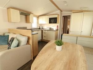 a kitchen and living room with a table and a couch at Blue Skies in Caernarfon