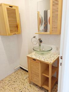 une salle de bain avec un lavabo en verre sur un comptoir dans l'établissement LE LOGIS, Appartement au pied de la plage, à Port-la-Nouvelle