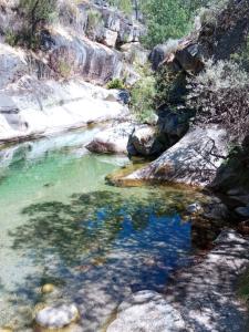 a pool of water in a river with rocks at Piscinas, Serra da Estrela AL in Bouça