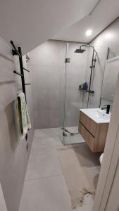 a white bathroom with a shower and a sink at Piscinas, Serra da Estrela AL in Bouça +25 photos