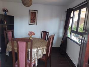 a dining room with a table and chairs and a window at El Descanso in Cochabamba