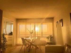 a living room with a table and chairs and a window at Koselig leilighet in Stavanger