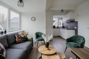 a living room with a couch and two chairs and a table at Brugs home 2 in Barneveld