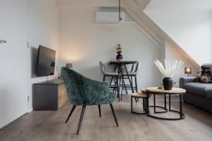 a living room with a couch and a chair and a table at Brugs home 2 in Barneveld
