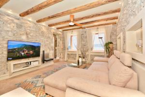 エルミオニにあるVillasonboard Rock Villa 3 Bed, 3 Bath, Jacuzzi, Seaside Ermioniのソファとテレビのあるリビングルーム