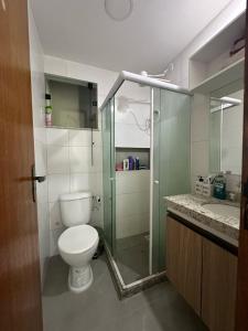 Un baño con inodoro y ducha de cristal. en apartamento recreio 5 min da praia, en Río de Janeiro 13 fotos más