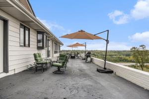 a patio with chairs and an umbrella on a house at Majestic VIEWS FunAmenities & Best for Huge Group in Council Bluffs