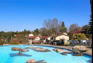 a large swimming pool with rocks in a yard at Panorama home 19 in Graskop