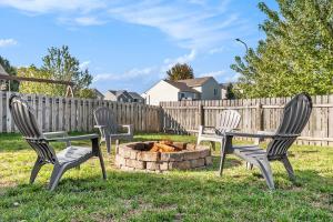 three chairs and a fire pit in a yard at Elegant Escape-Fenced Yard BBQ & Cozy Fire Pit in Omaha