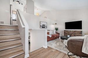 a white living room with a bed and a tv at Elegant Escape-Fenced Yard BBQ & Cozy Fire Pit in Omaha