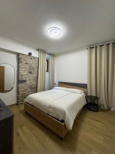 ein Schlafzimmer mit einem großen Bett und einer Steinwand in der Unterkunft Rustico cota in Tignale