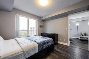 a bedroom with a bed and a window and a couch at Urban Oasis - Modern 1 bedroom w pool access free parking in Toronto