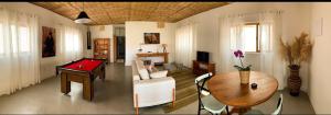 a living room with a ping pong table and a room with a pool table at Mar Egeu Arte & Pouso in Peruíbe
