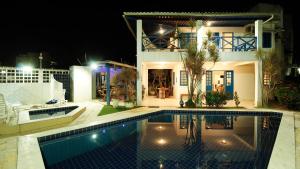 a house with a swimming pool at night at Casa da Nina | Beira-mar in Tamandaré