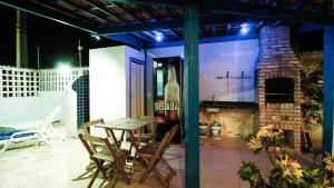 a patio with a table and chairs and a fireplace at Casa da Nina | Beira-mar in Tamandaré