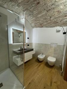ein Badezimmer mit Dusche, Waschbecken und Toilette in der Unterkunft Rustico cota in Tignale