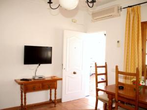 a room with a television and a table and a door at Apartamento Caracola Comfortable holiday residence in Chipiona
