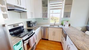 a kitchen with white cabinets and a stove top oven at The One in Folly Beach +41 photos