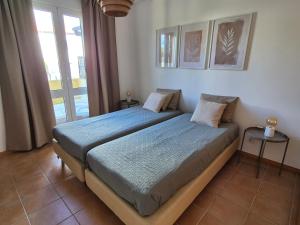 ein Schlafzimmer mit einem Bett und einem Fenster in der Unterkunft Cantinho do Porto Santo in Porto Santo