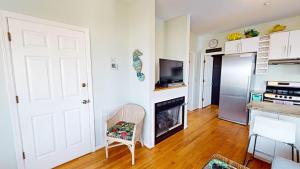 a kitchen with a white door and a chair in a room at The One in Folly Beach