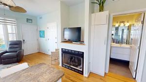 a living room with a fireplace and a tv at The One in Folly Beach