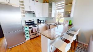 a kitchen with white cabinets and a marble counter top at The One in Folly Beach