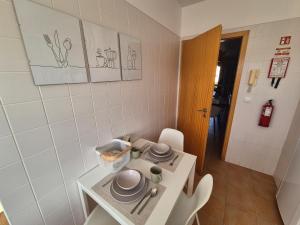 eine kleine Küche mit einem Tisch mit Geschirr darauf in der Unterkunft Cantinho do Porto Santo in Porto Santo + 23 Fotos