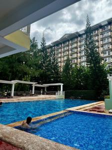 a man laying in a swimming pool in a hotel at Fully furnished 2 bedroom in Camella in Davao City