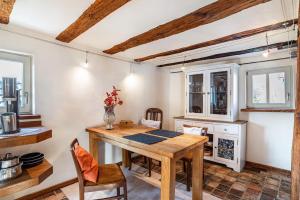 a dining room with a wooden table and chairs at Studiowohnung im preisgekrönten Denkmal in Groß-Umstadt in Groß-Umstadt +11 photos