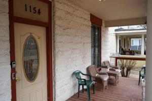 a front door of a house with chairs and a table at Chic Midtown 6BR Main house and 3BR Cottage in Memphis