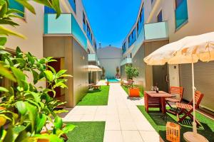 a courtyard of a building with chairs and an umbrella at Executive Townhouse, Tavira Centre, Shared Pool in Tavira