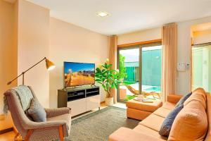 a living room with a couch and a television at Executive Townhouse, Tavira Centre, Shared Pool in Tavira
