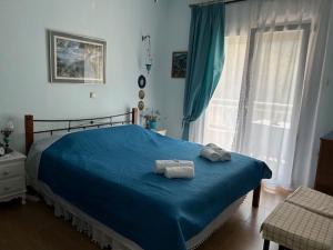 a bedroom with a blue bed with towels on it at Villa Palma in Skala Rachoniou