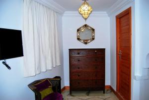 Zimmer mit einer Kommode und einem Spiegel an der Wand in der Unterkunft Dar terrae plus in Chefchaouen