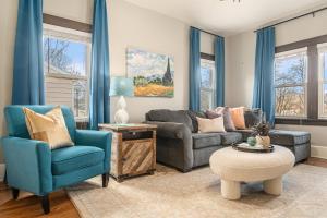 a living room with a couch and blue chairs at Benson's Cozy 3-BR Retreat with BBQ Grill in Omaha