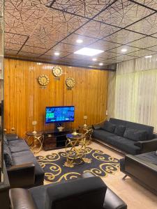 a living room with couches and a tv and clocks at Mk Big boss otel in Erzurum
