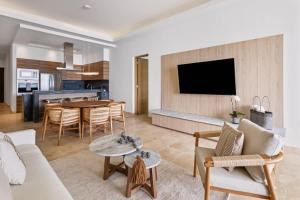 a living room with a couch and a table at Live Aqua Private Residences La Paz in La Paz