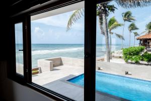 una ventana con vistas a la piscina y al océano en Xaman Ha Villa 30- PlayaCar- phase I, en Playa del Carmen 6 fotos más