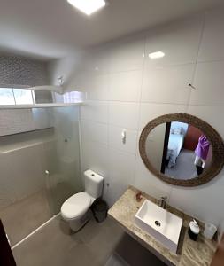 ein Badezimmer mit Toilette, Waschbecken und Spiegel in der Unterkunft Casa BAM - 5 quartos, piscina e churrasqueira in Barra Grande + 15 Fotos