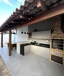 eine offene Küche mit einer Ziegelwand in der Unterkunft Casa BAM - 5 quartos, piscina e churrasqueira in Barra Grande