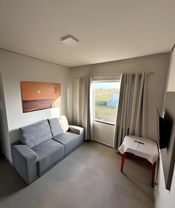 ein Wohnzimmer mit einer Couch und einem Fenster in der Unterkunft Casa BAM - 5 quartos, piscina e churrasqueira in Barra Grande