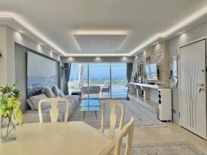 a living room with a couch and a table and chairs at Villasonboard 3 Bed Penthouse Veranda Beach view jacuzzi Vouliagmeni Riviera in Athens