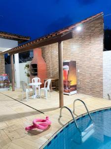 a pool with a table and chairs and a grill at Lucena House in Lucena