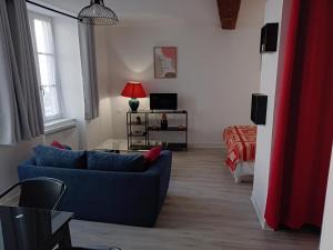 a living room with a blue couch and a bed at Studio Zoé in Saint-Père