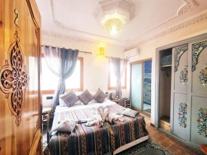 a bedroom with a bed and a large window at Hôtel&Restaurant Villa des étoiles in Ourika