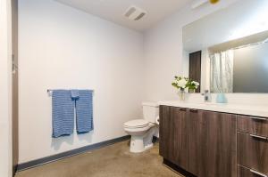 een badkamer met een toilet, een wastafel en een spiegel bij Adorable 2bed Apt Balcony & Rooftop Pool D in Los Angeles +7 foto's