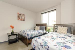 een slaapkamer met twee bedden en een raam bij Adorable 2bed Apt Balcony & Rooftop Pool D in Los Angeles