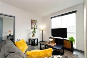 een woonkamer met een bank en een flatscreen-tv bij Adorable 2bed Apt Balcony & Rooftop Pool D in Los Angeles