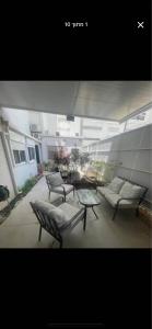 a patio with three chairs and a table in a building at יחידה שקטה ונעימה in Nahariyya